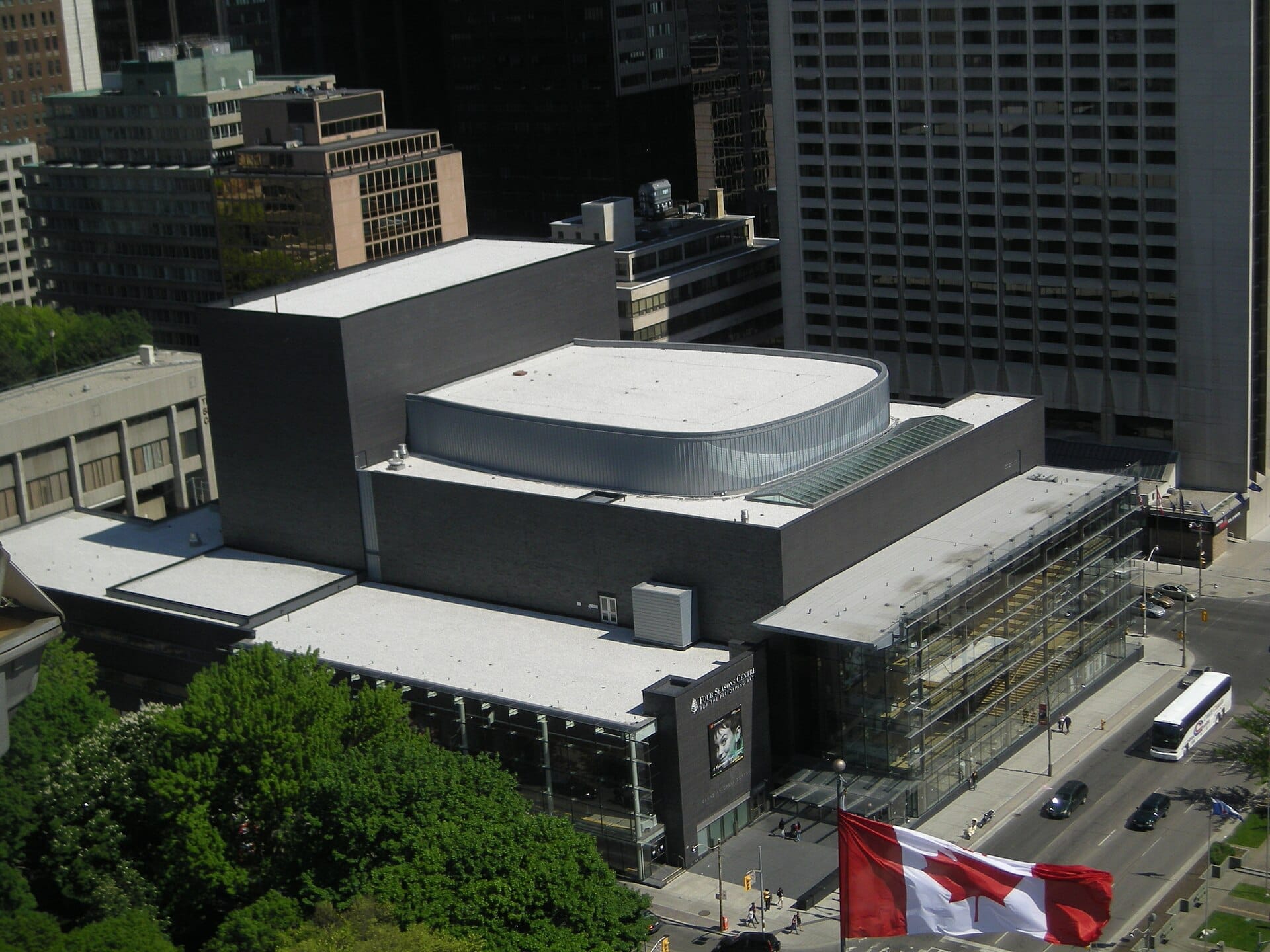 มุมมองทางอากาศของ Four Seasons Centre for the Performing Arts ในเมืองโตรอนโต โดดเด่นด้วยสถาปัตยกรรมสมัยใหม่และผนังกระจกที่ล้อมรอบด้วยอาคารในเมือง