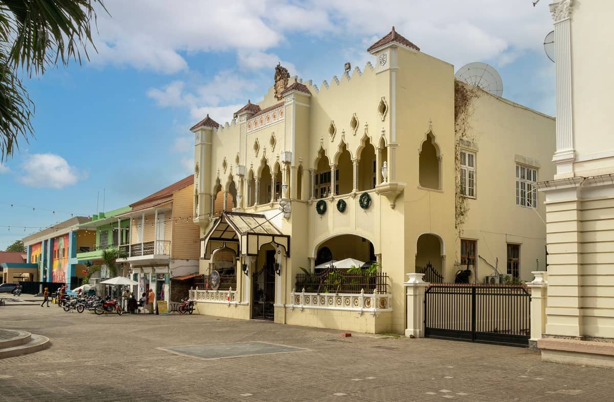 A yellow, ornately designed building on a main street in Stone Town, Zanzibar, with arched windows and decorative details, likely the Freddie Mercury Museum.