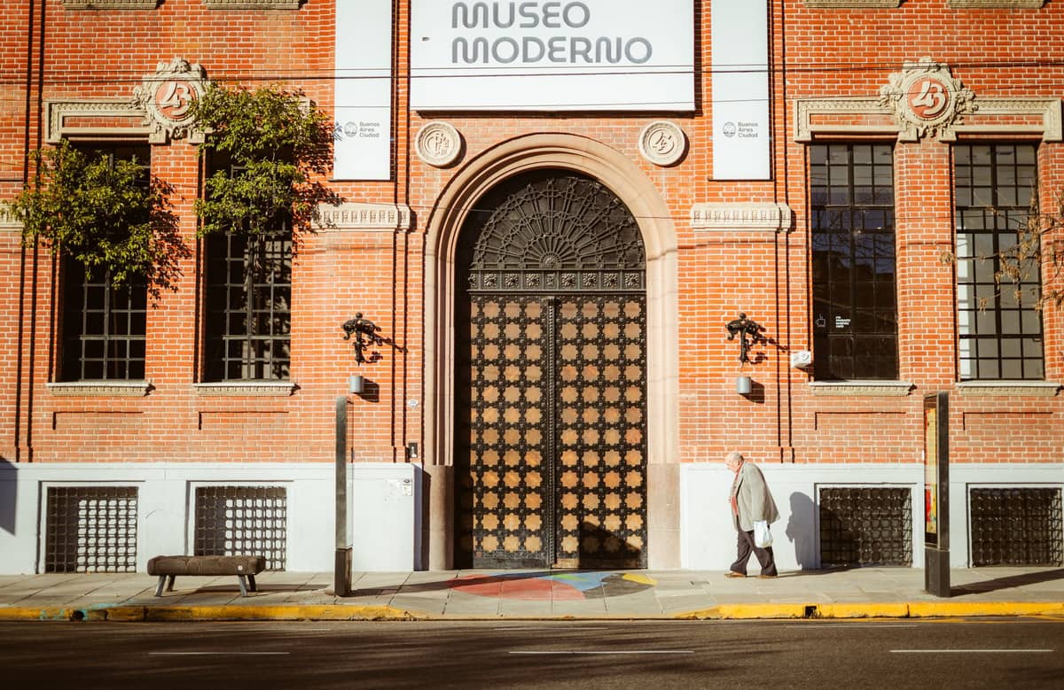 ด้านหน้าของ Museo Moderno ในบัวโนสไอเรส พร้อมประตูโค้งขนาดใหญ่และป้ายเหนือทางเข้า มีคนเดินผ่านในวันที่แดดจ้า