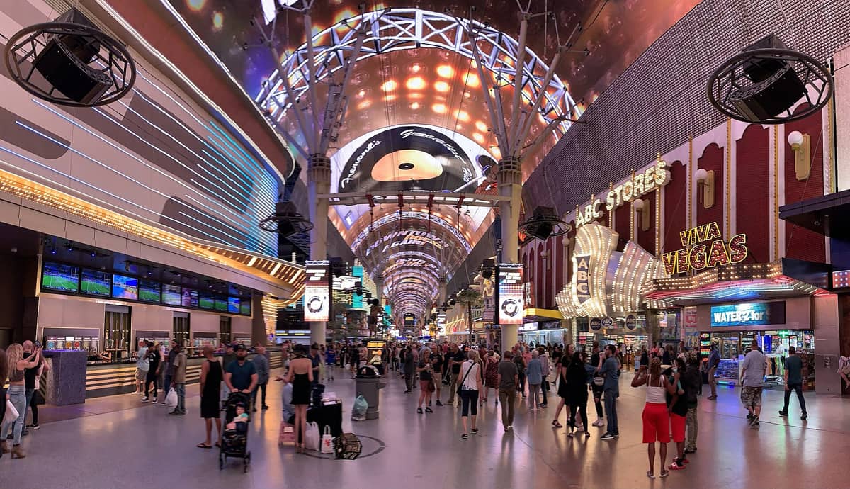 Vista amplia de Fremont Street Experience en el centro de Las Vegas con multitudes, letreros de neón y el icónico dosel de luces en lo alto.