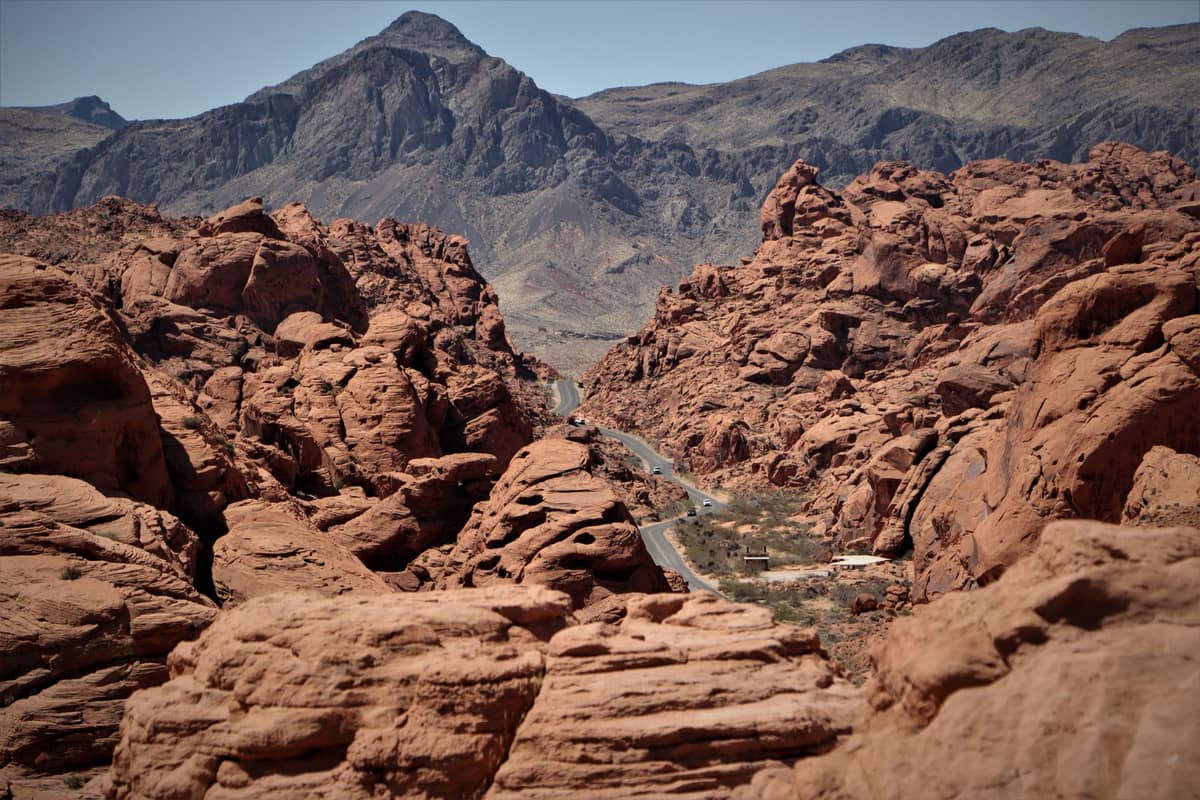 Una carretera sinuosa atraviesa dramáticas formaciones de roca roja y montañas cerca de Las Vegas, mostrando el accidentado paisaje desértico de Red Rock Canyon.