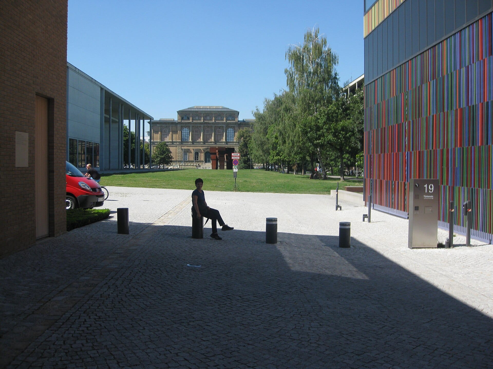 วิวของกลุ่มพิพิธภัณฑ์ Pinakothek ในมิวนิก พร้อมอาคารสมัยใหม่สีสันสดใส สนามหญ้าสีเขียว และ Alte Pinakothek อันเก่าแก่อยู่เบื้องหลัง
