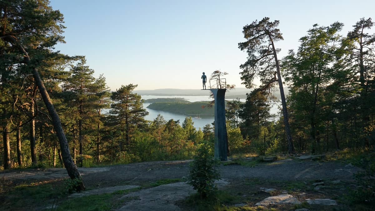 จุดชมวิวสวยงามในป่าสนที่มองเห็น Oslofjord พร้อมรูปปั้นบนเสาและเกาะต่างๆ ที่มองเห็นได้ในน้ำด้านล่าง
