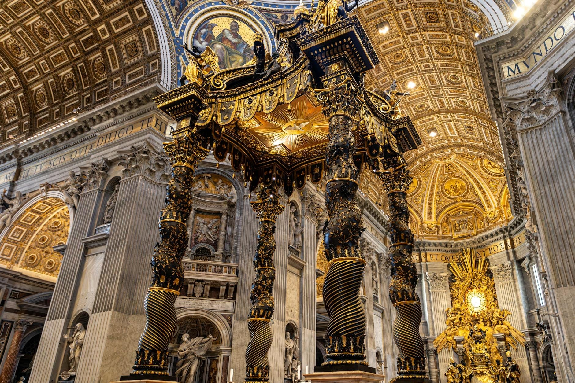Ornate golden baldachin and richly decorated dome in a grand Roman church interior with columns and religious art visible.