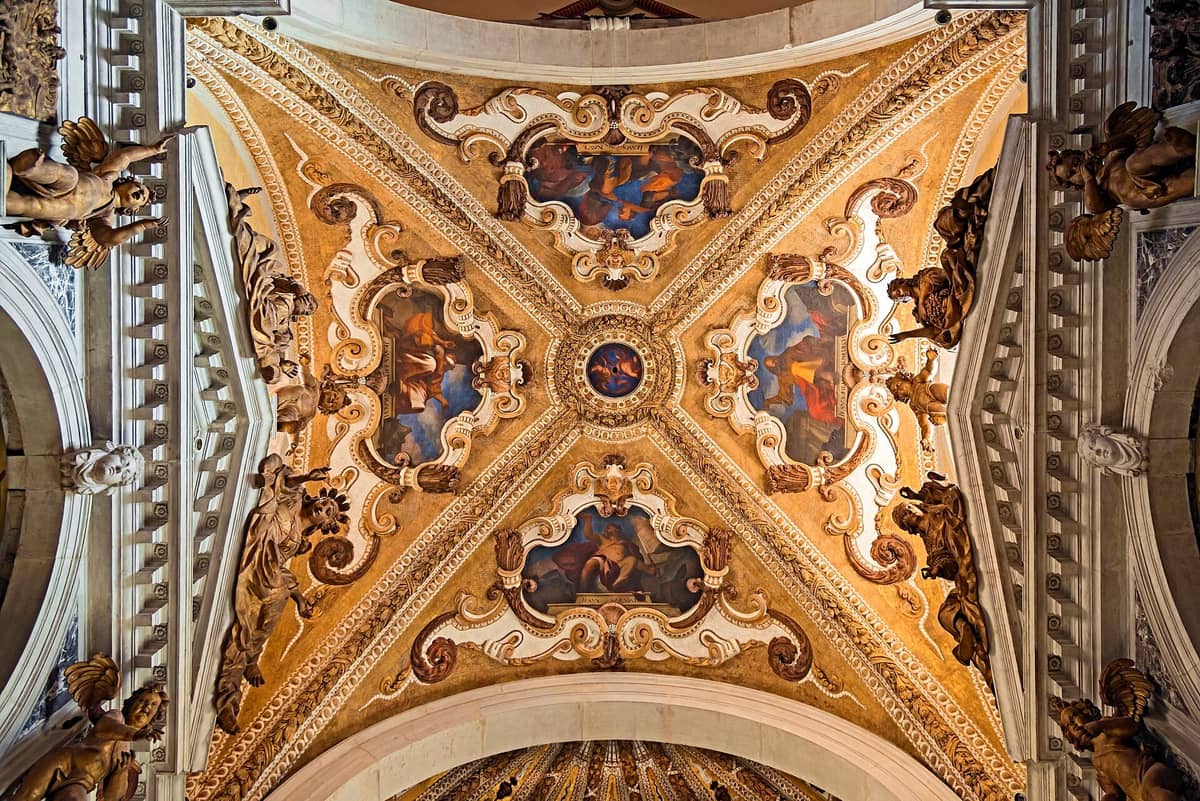 Reich verzierte Barockdecke mit Fresken und gemeißelten Engeln im Inneren einer venezianischen Kirche, die detaillierte sakrale Kunst und architektonischen Reichtum zeigt.