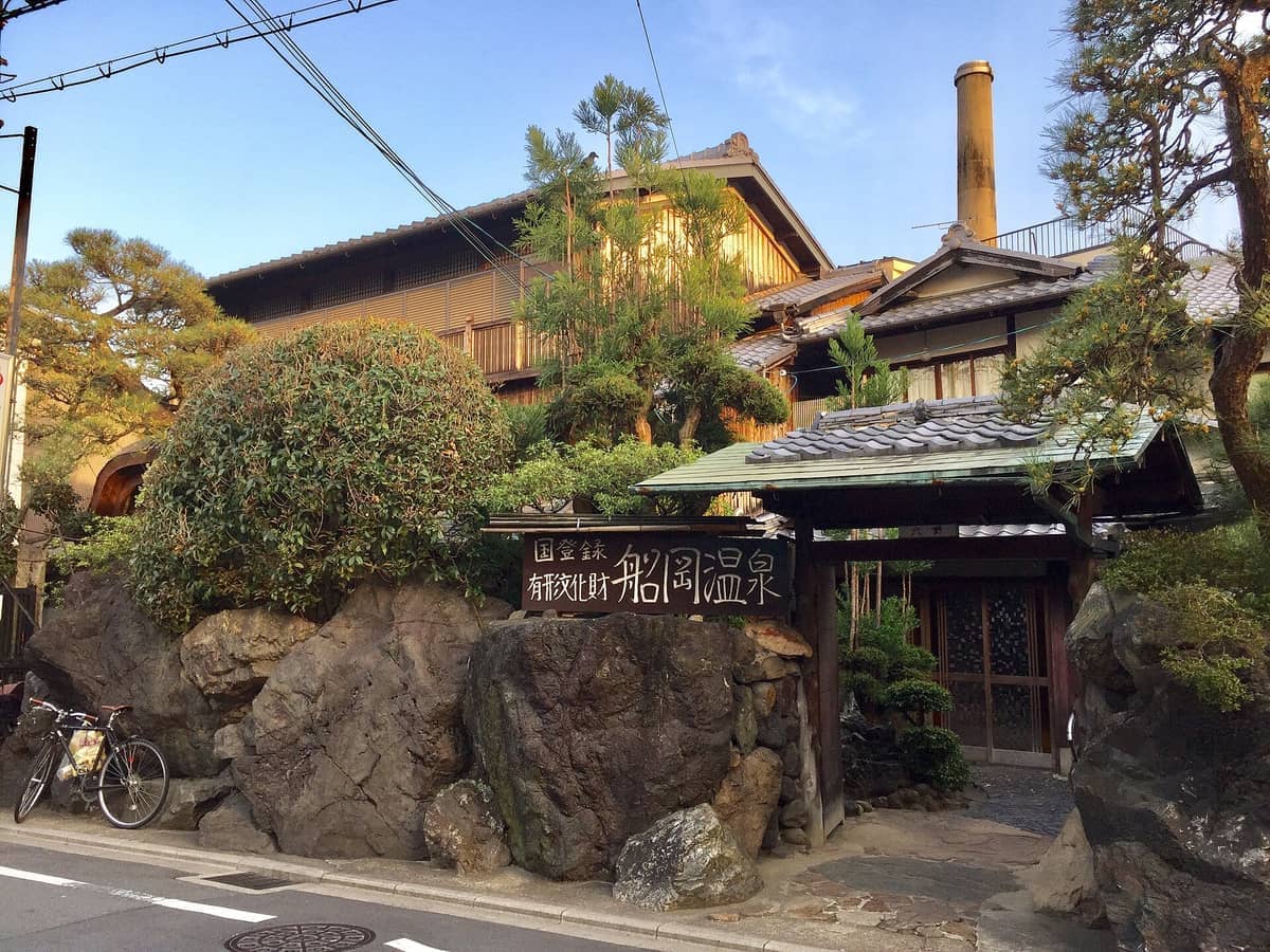 Traditional Japanese architecture and stone garden mark the entrance to Funaoka Onsen bathhouse in Kyoto’s historic Nishijin district.