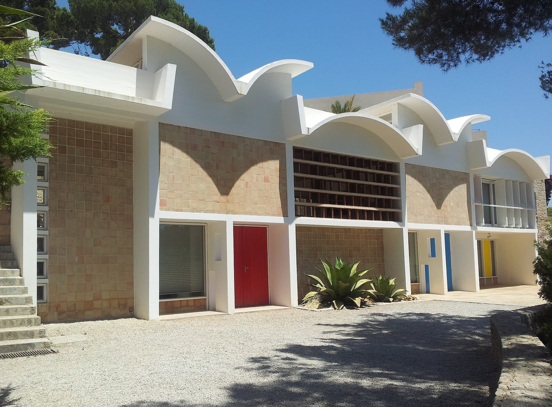 Esterno della Fundació Pilar i Joan Miró a Palma, con architettura modernista caratterizzata da tetti bianchi curvi e accenti geometrici rossi, blu e gialli.
