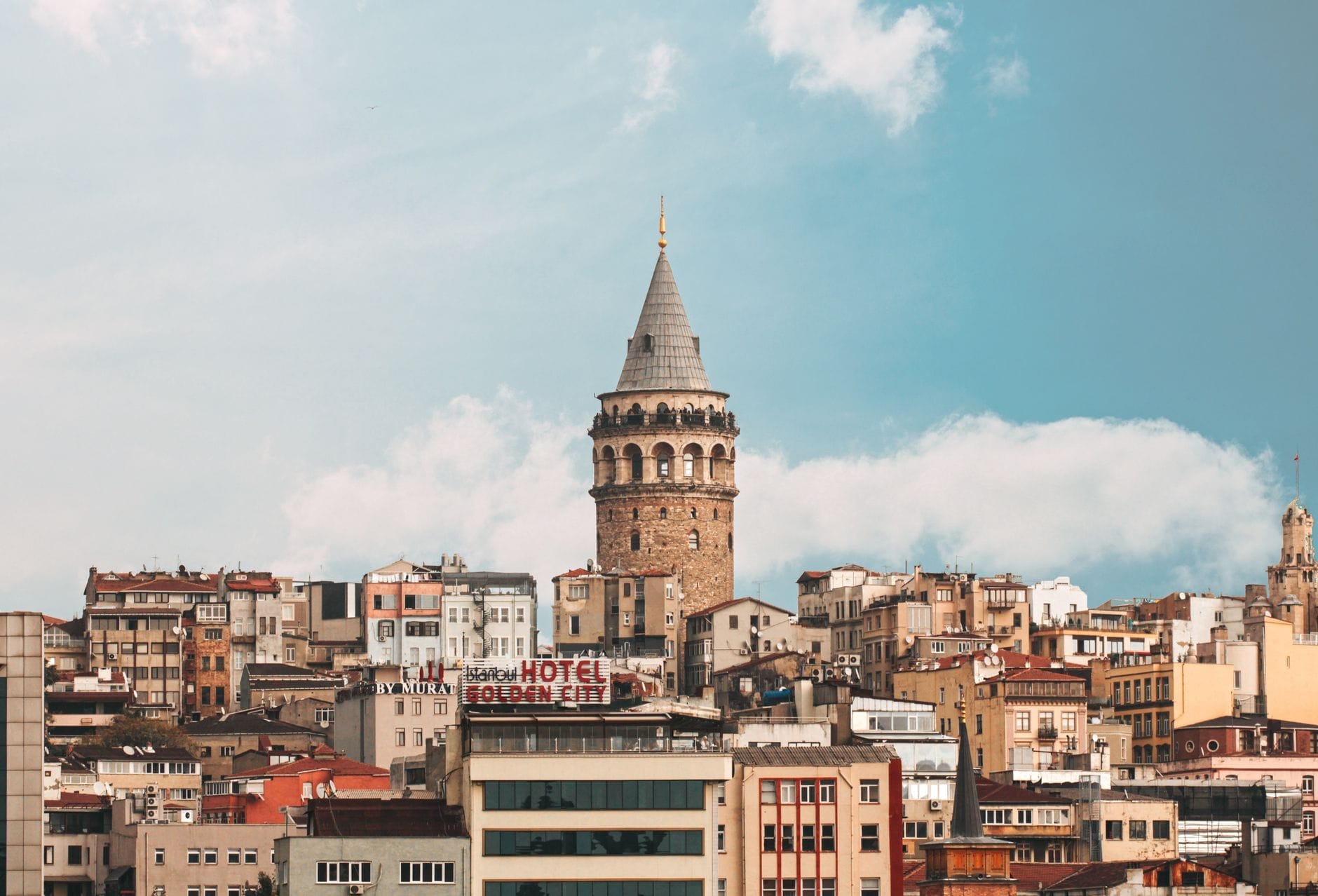 La Torre di Galata si erge imponente sopra i colorati edifici della città sotto un cielo azzurro con qualche nuvola sparse, Istanbul, Turchia.