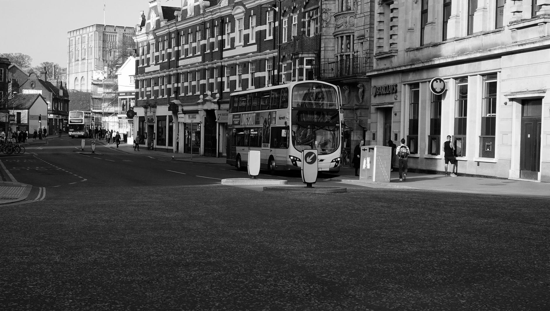 Ein moderner Doppeldeckerbus auf einer städtischen Straße, gesäumt von klassischen britischen Gebäuden, typisch für den Stadtverkehr von Brighton.
