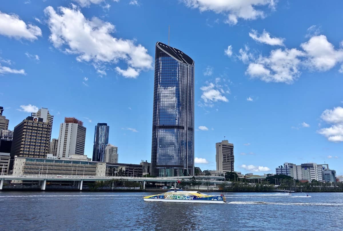 Brisbane River CityCat ferry gliding past the city skyline and waterfront on a sunny day, showing public transport on the water in Brisbane.