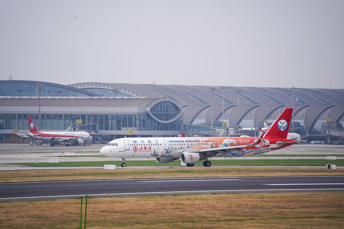Avión de Sichuan Airlines en la pista frente a una terminal moderna en un gran aeropuerto de Chengdu