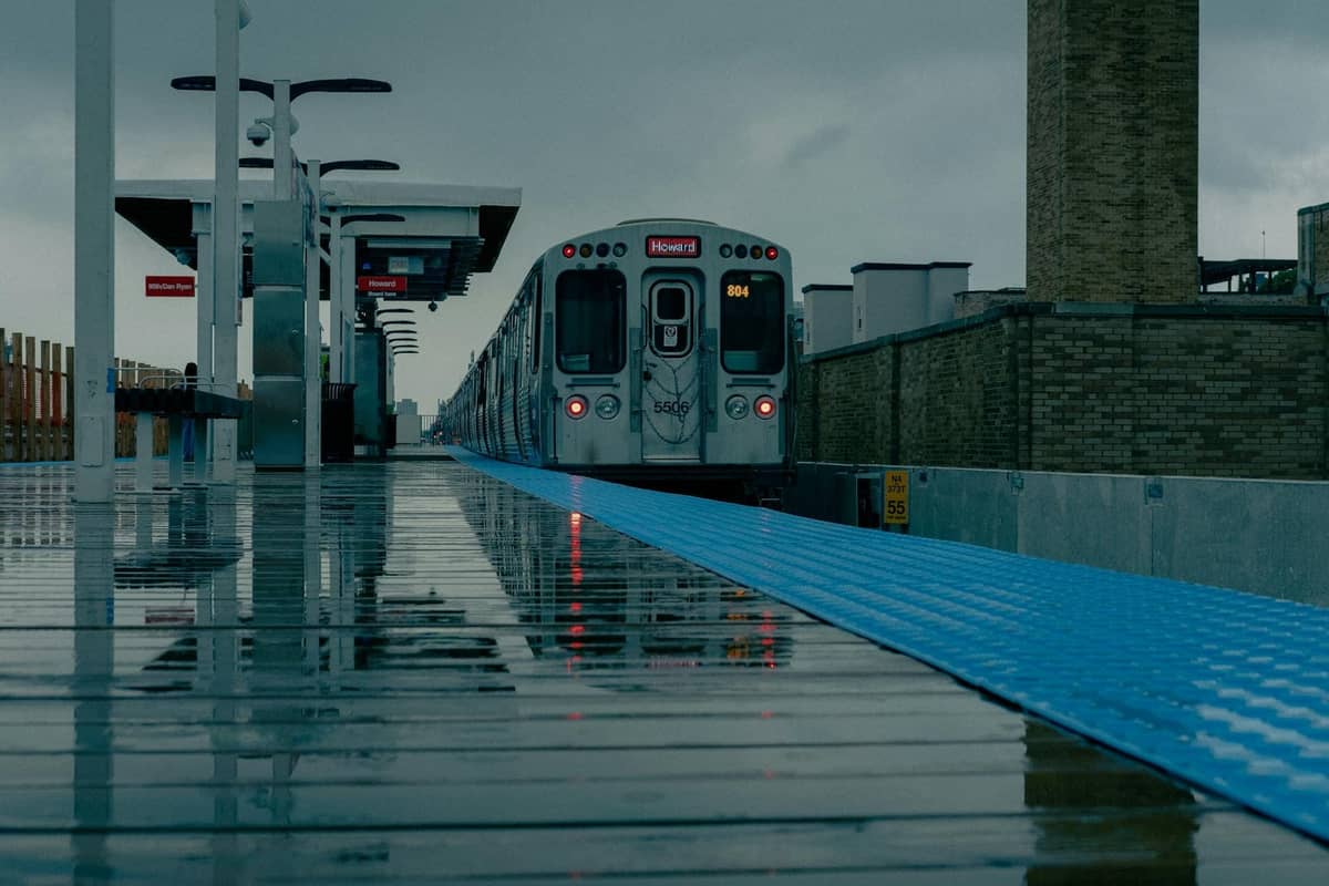 A Chicago CTA train at the O'Hare station platform on a rainy day, highlighting the start of the Blue Line route downtown.