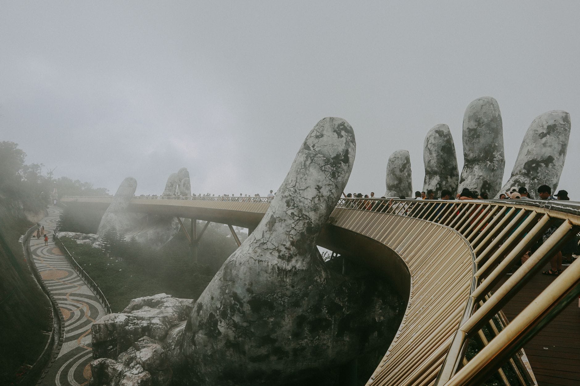 สะพาน Golden Bridge ที่ Ba Na Hills สถานที่ท่องเที่ยวชื่อดังใกล้กับ Da Nang มีมือหินขนาดใหญ่รองรับสะพานคนเดินเท้าท่ามกลางสายหมอก