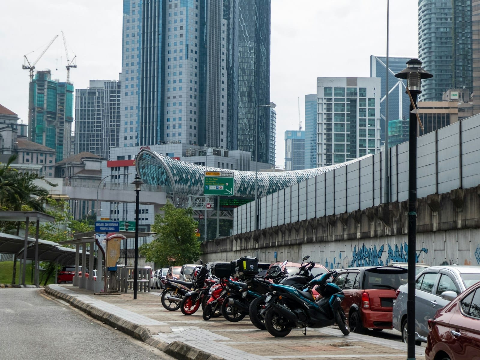 Vibrant Kuala Lumpur MRT station with commuters boarding sleek green line trains amid modern urban architecture.