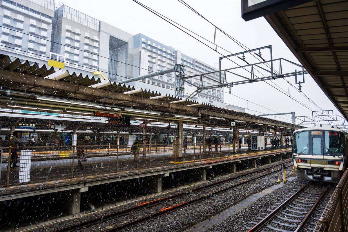 View of Kyoto Station platforms with JR trains and modern station building in the background, illustrating key transport hub in Kyoto.