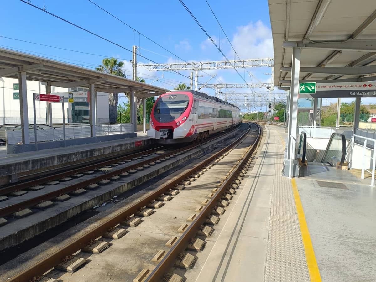Tàu điện ngoại ô hiện đại tại sân ga ngoài trời ở Mallorca, với biển hiệu rõ ràng và bầu trời xanh.