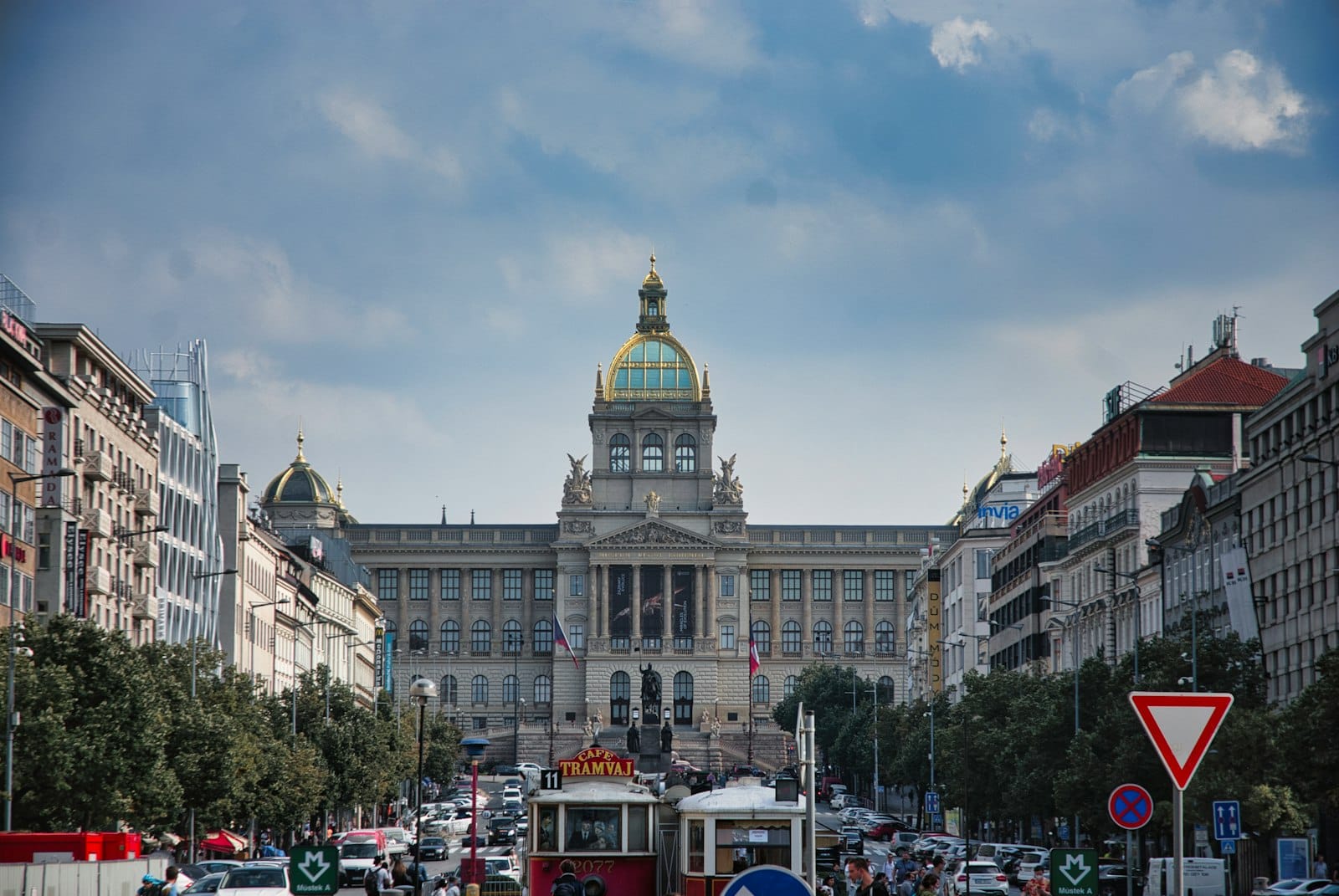Belebte Straße vor dem Nationalmuseum Prag mit mehreren Autos und einigen Taxis, die den Stadtverkehr am Wenzelsplatz zeigt.
