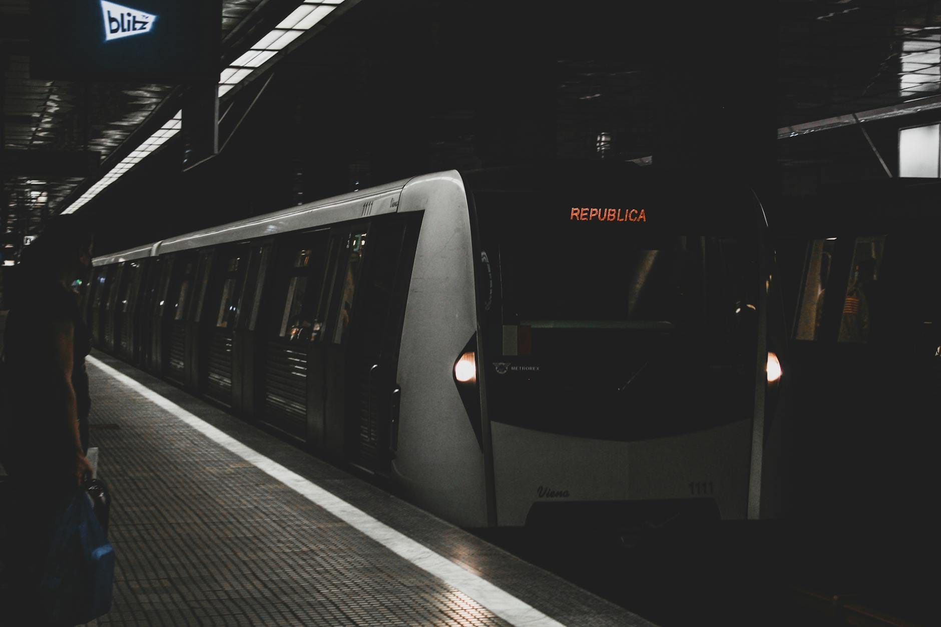 Rome metro train at Repubblica station, platform view with passengers and signage in a dimly lit underground station.