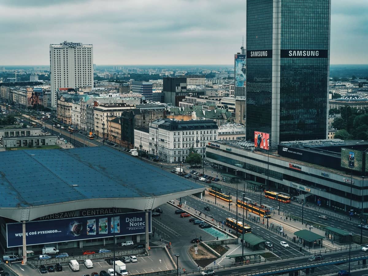 Pemandangan udara Stasiun kereta Warsaw Central dengan mobil, taksi, dan gedung-gedung kota di latar belakang.