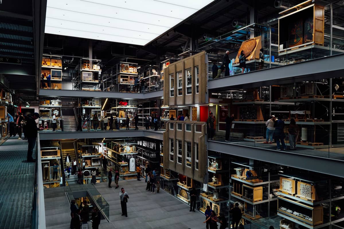 Modern, multi-level museum interior filled with various exhibits and families exploring interactive displays in Ghent.