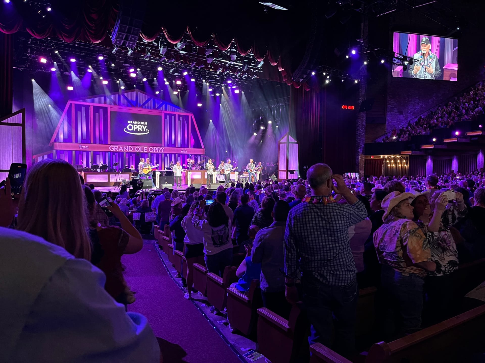 Público numeroso en el Grand Ole Opry House viendo una actuación en vivo de música country en un escenario iluminado en Nashville.