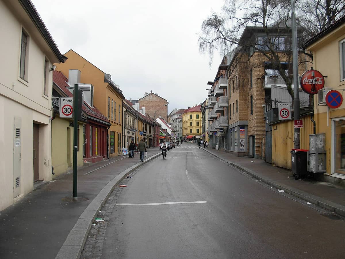 ภาพถนนในย่าน Grønland ของออสโล ตึกสีสันสดใส ร้านค้า และผู้คนที่เดินผ่านท่ามกลางบรรยากาศหลากหลายวัฒนธรรม