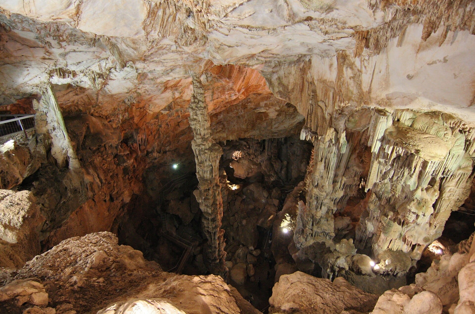 Blick ins Innere der Grotte di Ispinigoli mit dem aufragenden Kalkstein-Stalagmiten, dramatischen Felsformationen und beleuchteten Höhlenwänden.