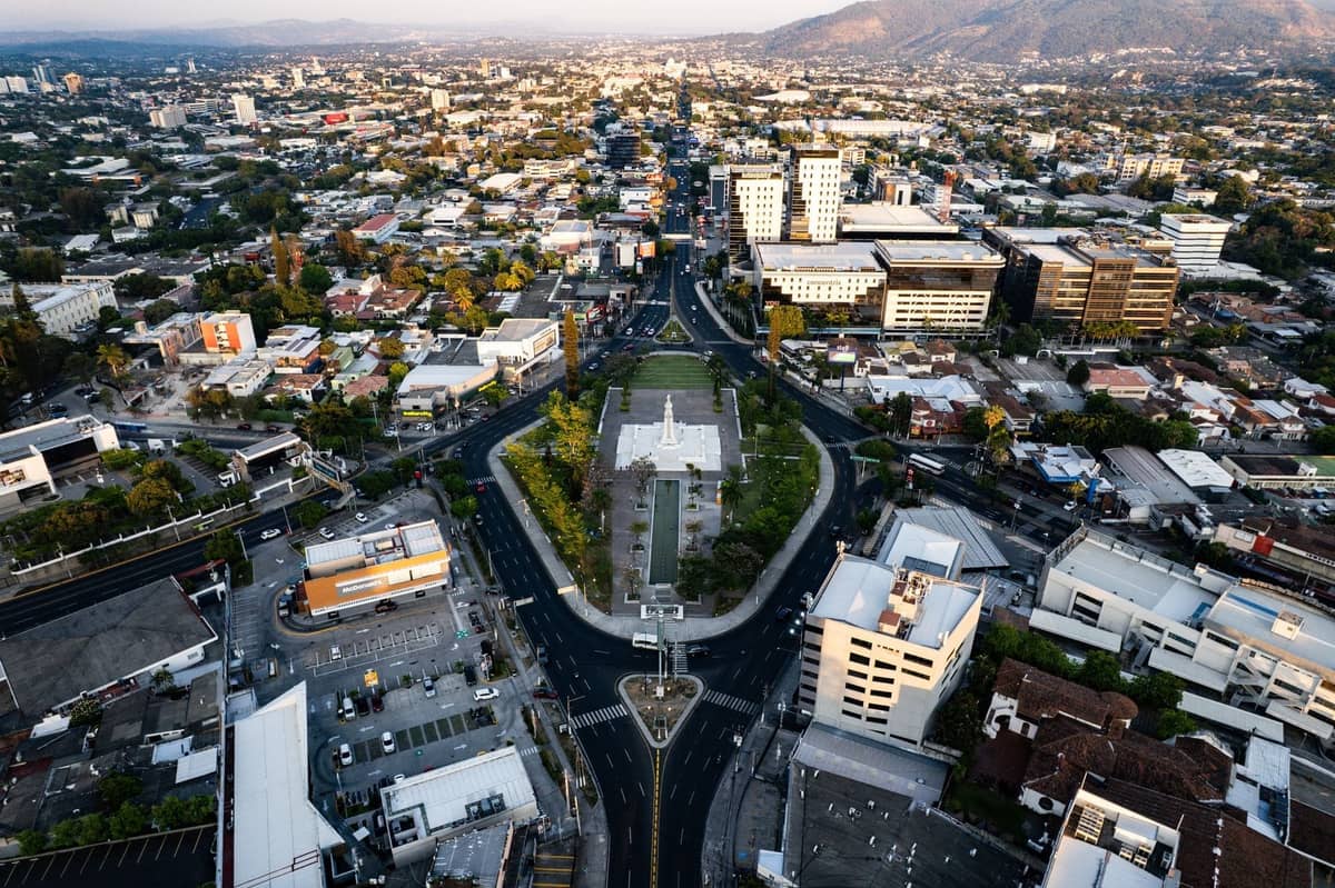 Luftaufnahme von Guadalajara mit belebten Stadtstraßen, Gebäuden und städtischer Ausdehnung bis hin zu fernen Bergen.
