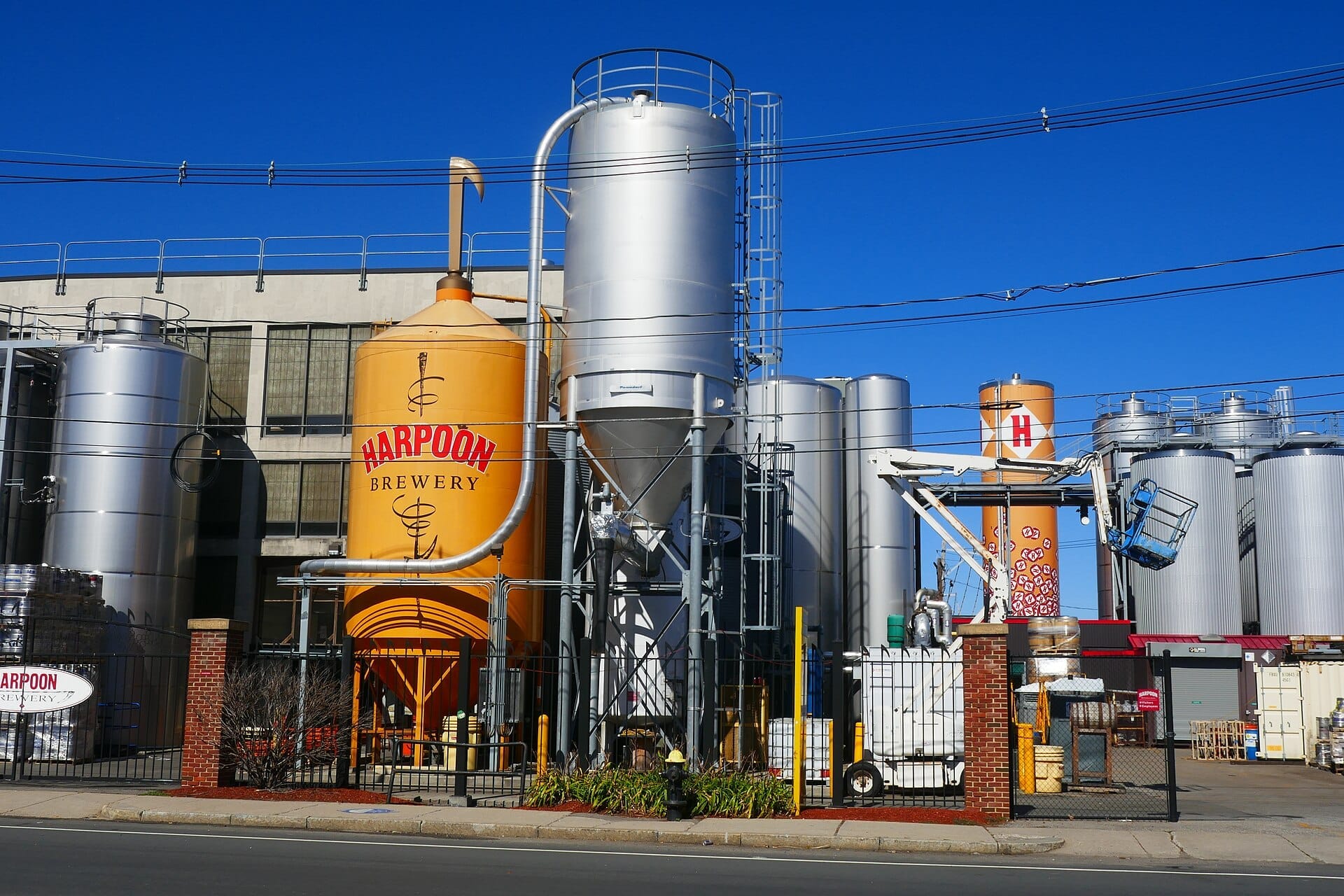 Esterno della Harpoon Brewery con grandi serbatoi di fermentazione e silos in acciaio inossidabile in una giornata di sole nel Seaport District di Boston.