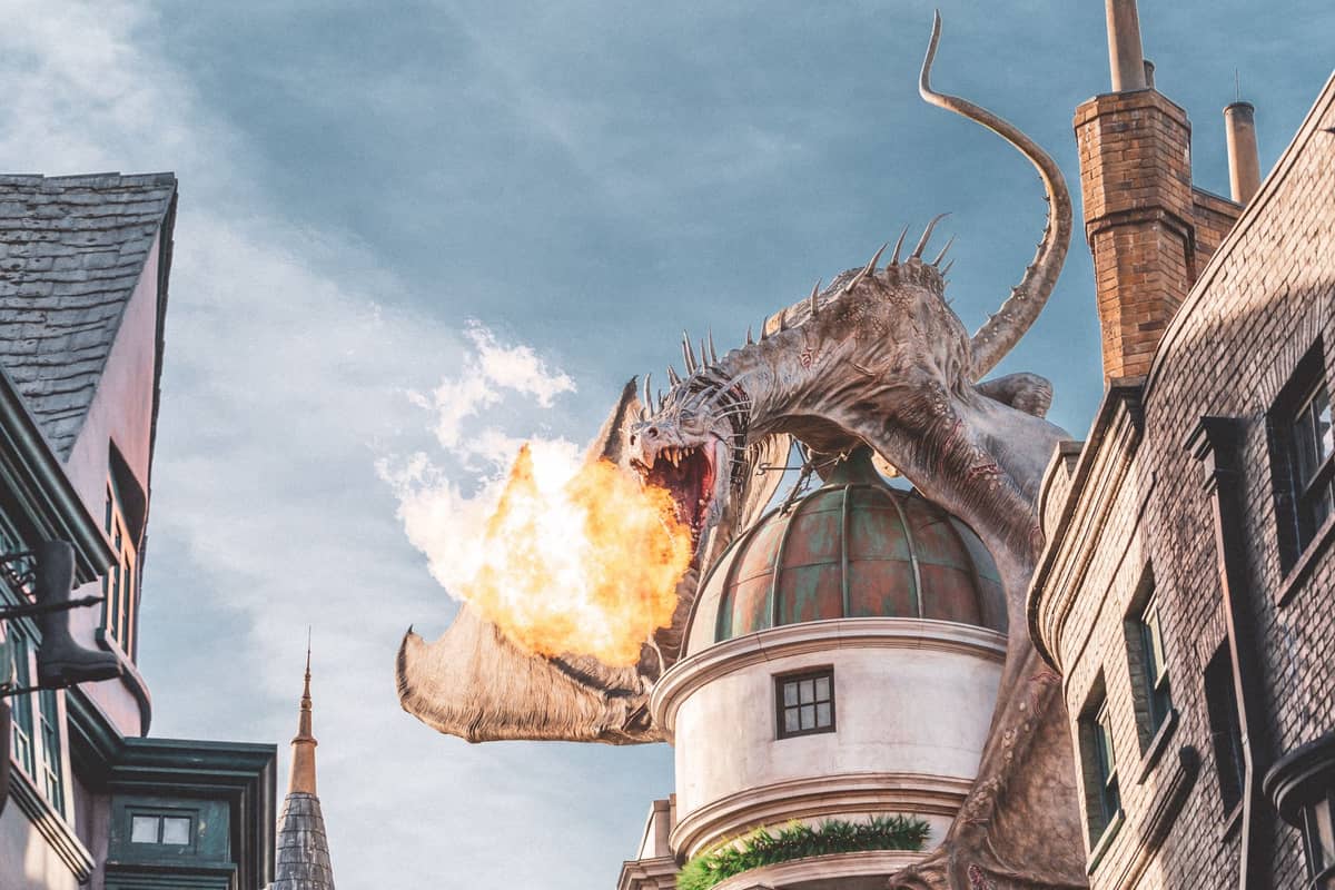 Der feuerspeiende Drache auf der Gringotts-Bank in der Diagon Alley der Zauberwelt von Harry Potter im Universal Orlando, umgeben von detailreich gestalteten Zauberergebäuden.