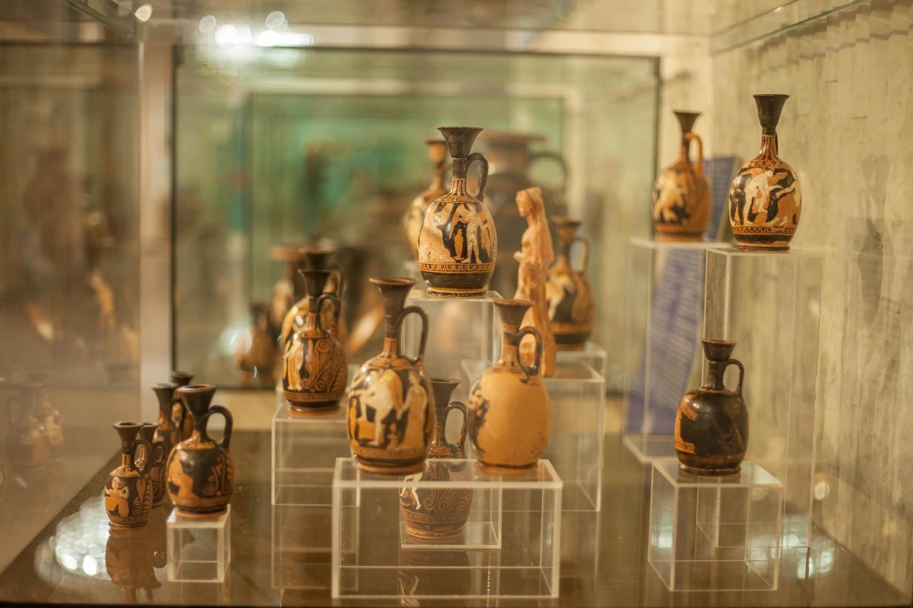 Teche espositive con ceramiche e reperti minoici all'interno del Museo Archeologico di Heraklion, con la sua celebre collezione minoica illuminata da una luce soffusa e un'atmosfera raccolta.