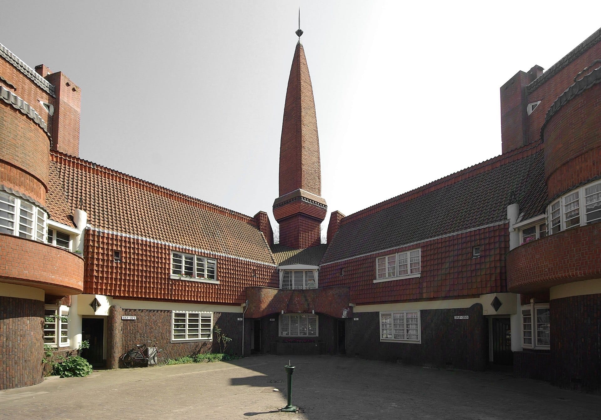 Vista exterior del Museum Het Schip, con su característico trabajo en ladrillo, ventanas curvas y aguja central bajo la luz del día en Ámsterdam.