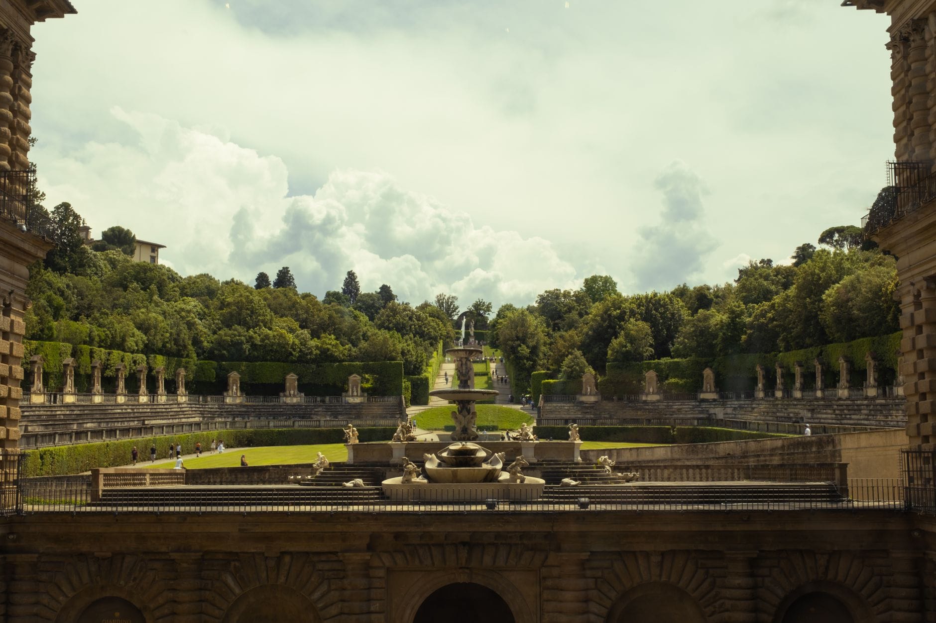 วิวกว้างของระเบียงอย่างเป็นทางการและน้ำพุของสวน Boboli Gardens ที่ทอดยาวสู่ระยะไกล ล้อมรอบด้วยพืชพันธุ์เขียวขจีและสถาปัตยกรรมพระราชวังในเมือง Florence