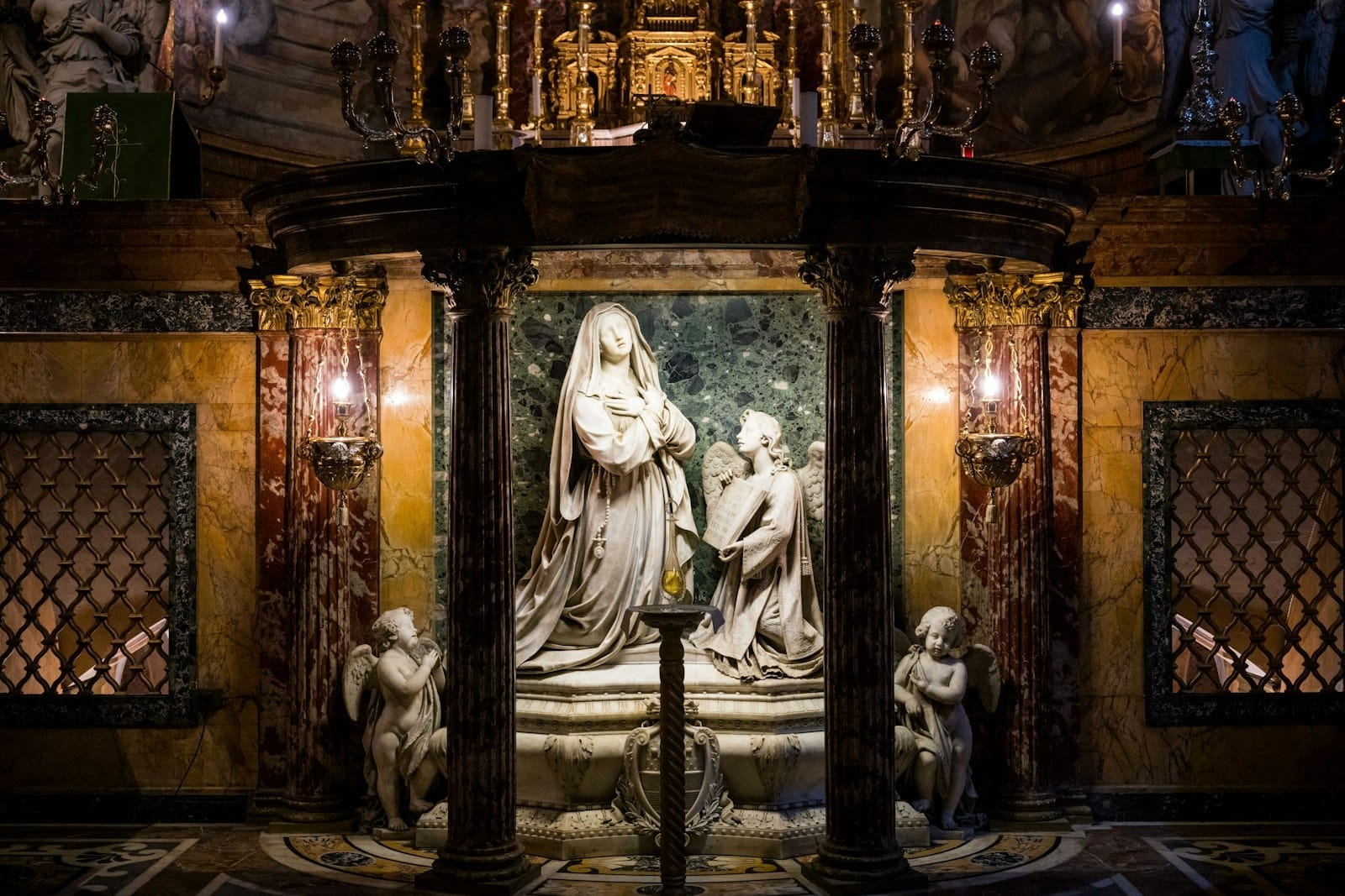 Marble altar with detailed statues and golden decorations in a richly adorned Roman church interior.
