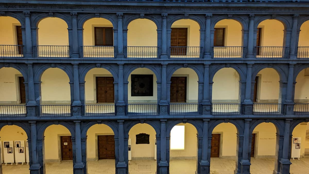 Innenhof eines historischen Gebäudes mit mehreren Bögen und Balkonen, möglicherweise Teil eines weniger bekannten Museums oder einer Kultursammlung in Madrid.