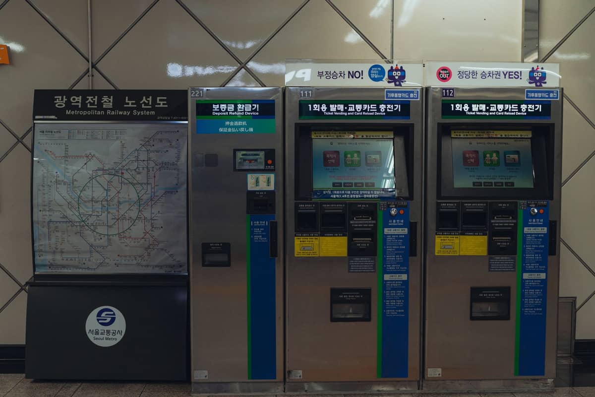 Máquinas de bilhetes de metrô e um mapa detalhado do Metrô Metropolitano de Seul dentro de uma estação, mostrando a acessibilidade urbana.