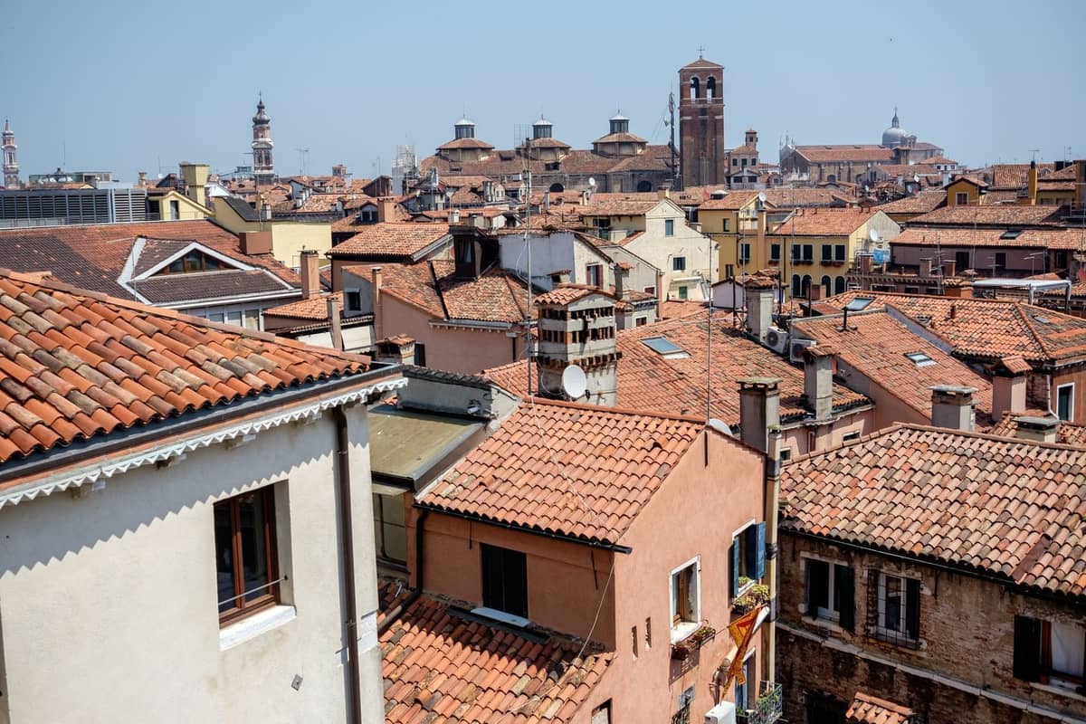 Dachterrassenblick über Venedig mit Terrakottadächern, historischen Glockentürmen und engen Gassen, der die verborgenen Perspektiven weniger besuchter Aussichtspunkte einfängt.