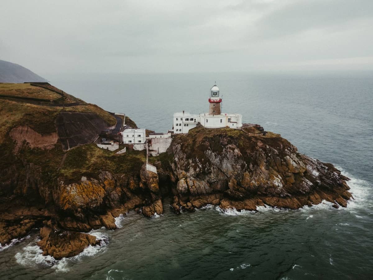 Un phare spectaculaire perché sur des falaises rocheuses surplombant l'océan près de Dublin, exemple parfait de promenades côtières et de sentiers sur les falaises.