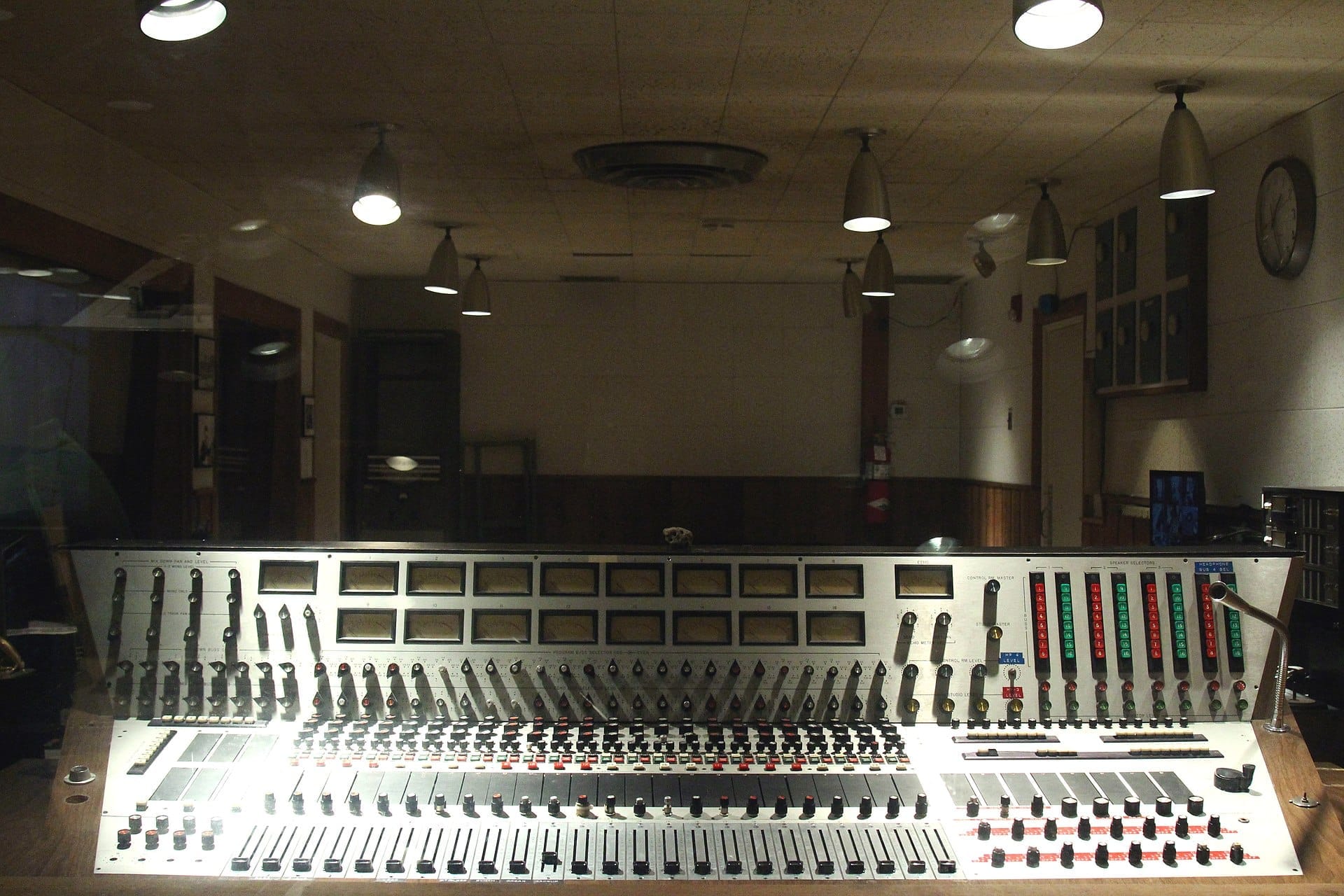 Mesa de mezclas vintage y controles analógicos en el interior de RCA Studio B, el legendario estudio de grabación de Nashville, con iluminación tenue y detalles históricos.