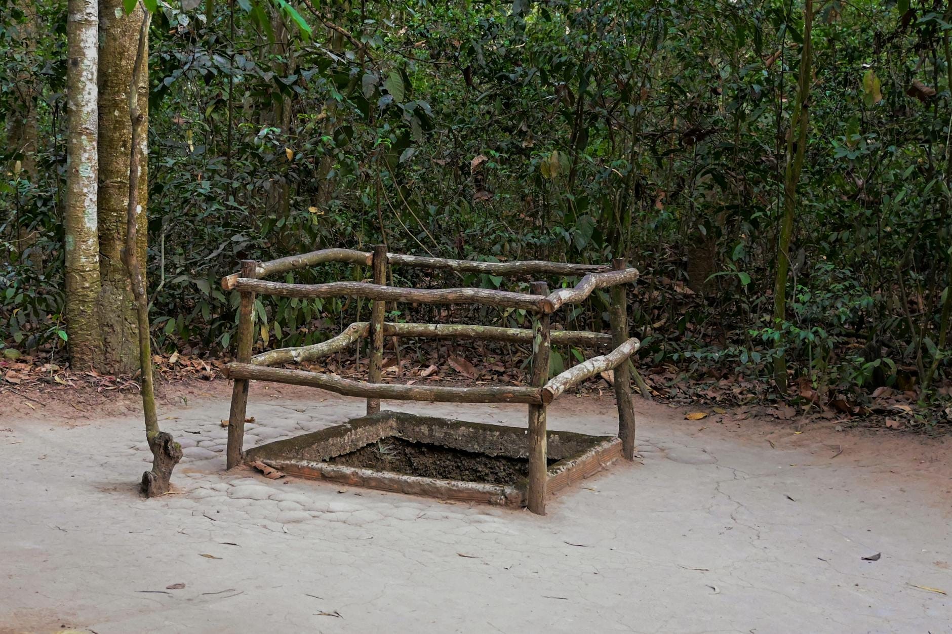Una entrada camuflada a los Túneles de Cu Chi rodeada por una cerca de madera, situada en una zona boscosa cerca de Ho Chi Minh City.