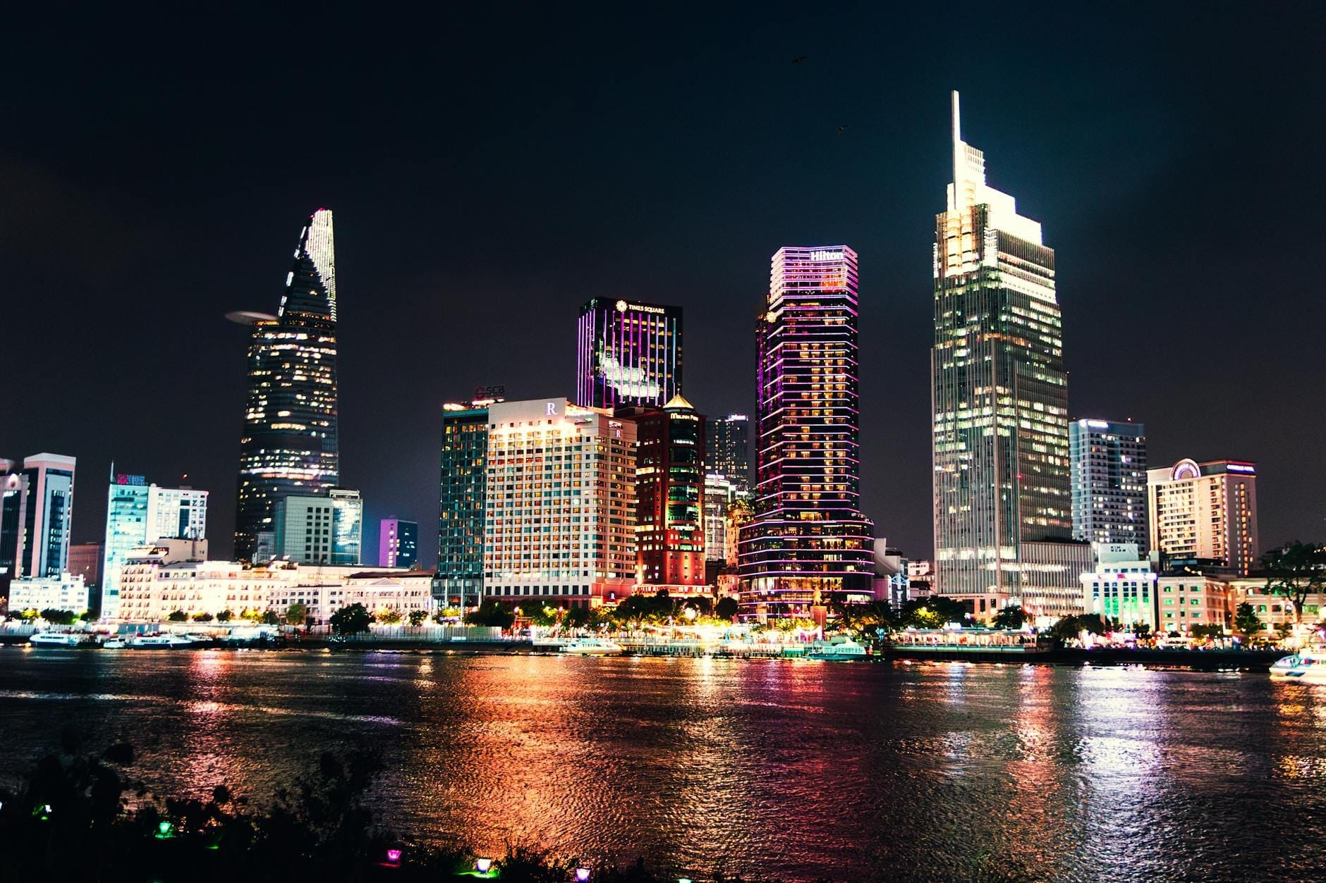 Vista nocturna de la Ópera de Ho Chi Minh City con rastros de luz y hoteles de gran altura iluminados en el centro de la ciudad.