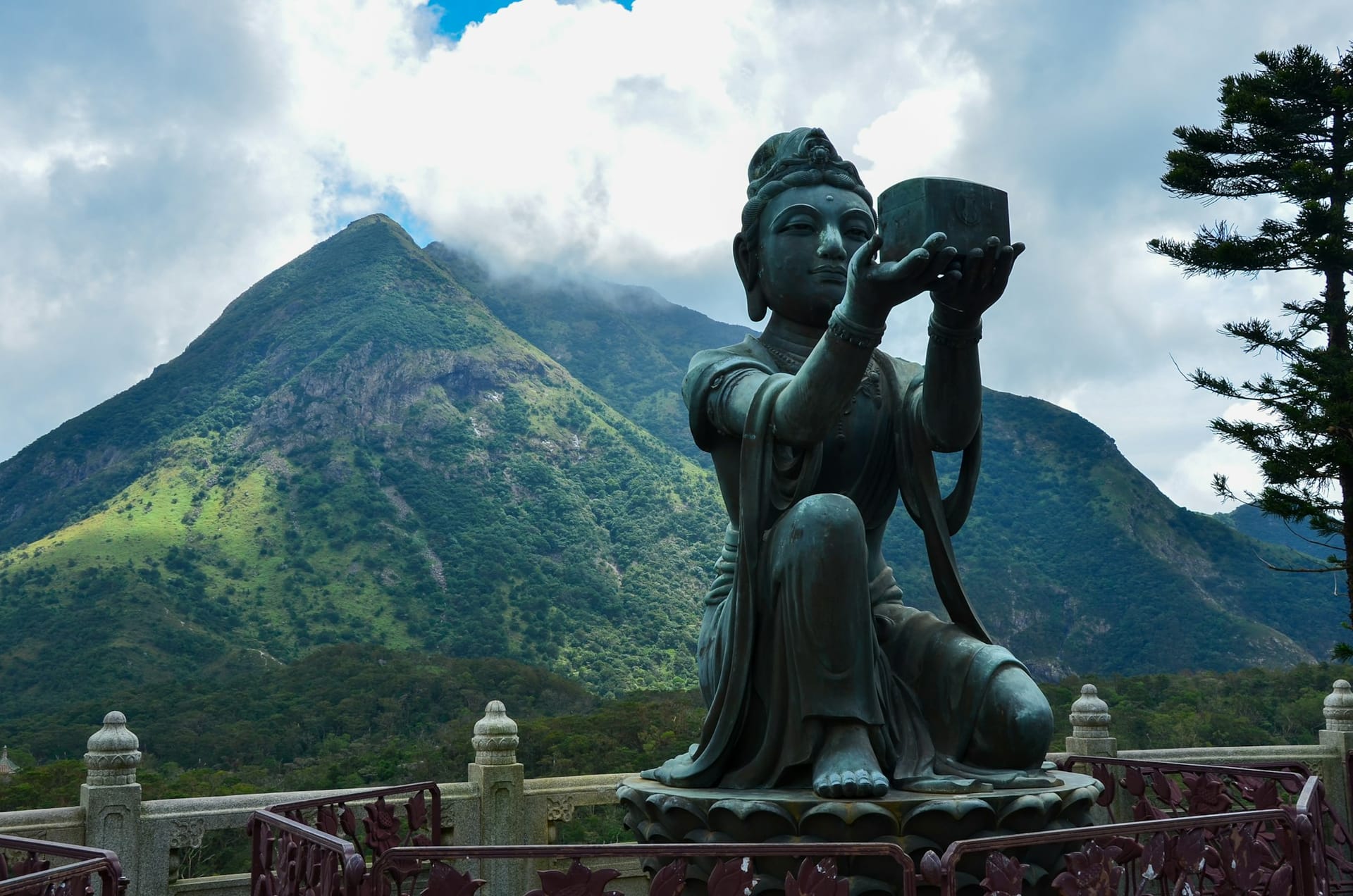 Statue bouddhiste sur l'île de Lantau avec montagnes vertes en arrière-plan, Hong Kong