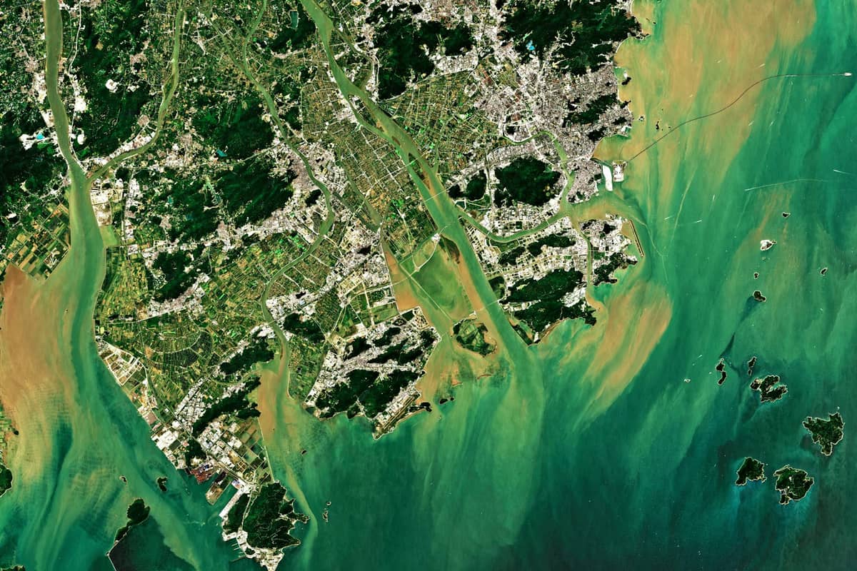 Satellitenansicht von Land und Wasser rund um das Perlfluss-Delta mit Hong Kong, Macau und den umliegenden Inseln.