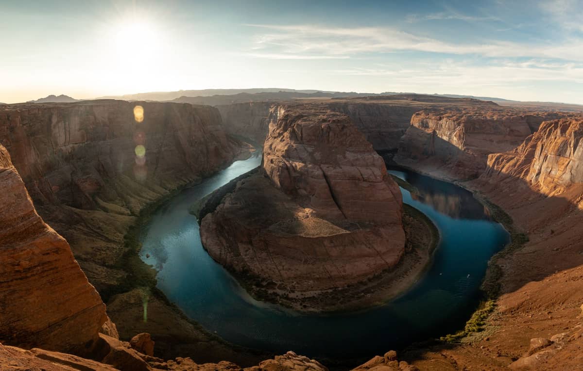 Panoramiczny widok na Horseshoe Bend — rzeka Kolorado zatacza dramatyczny łuk o 270 stopni wokół ogromnej formacji skalnej w Arizonie o zachodzie słońca.