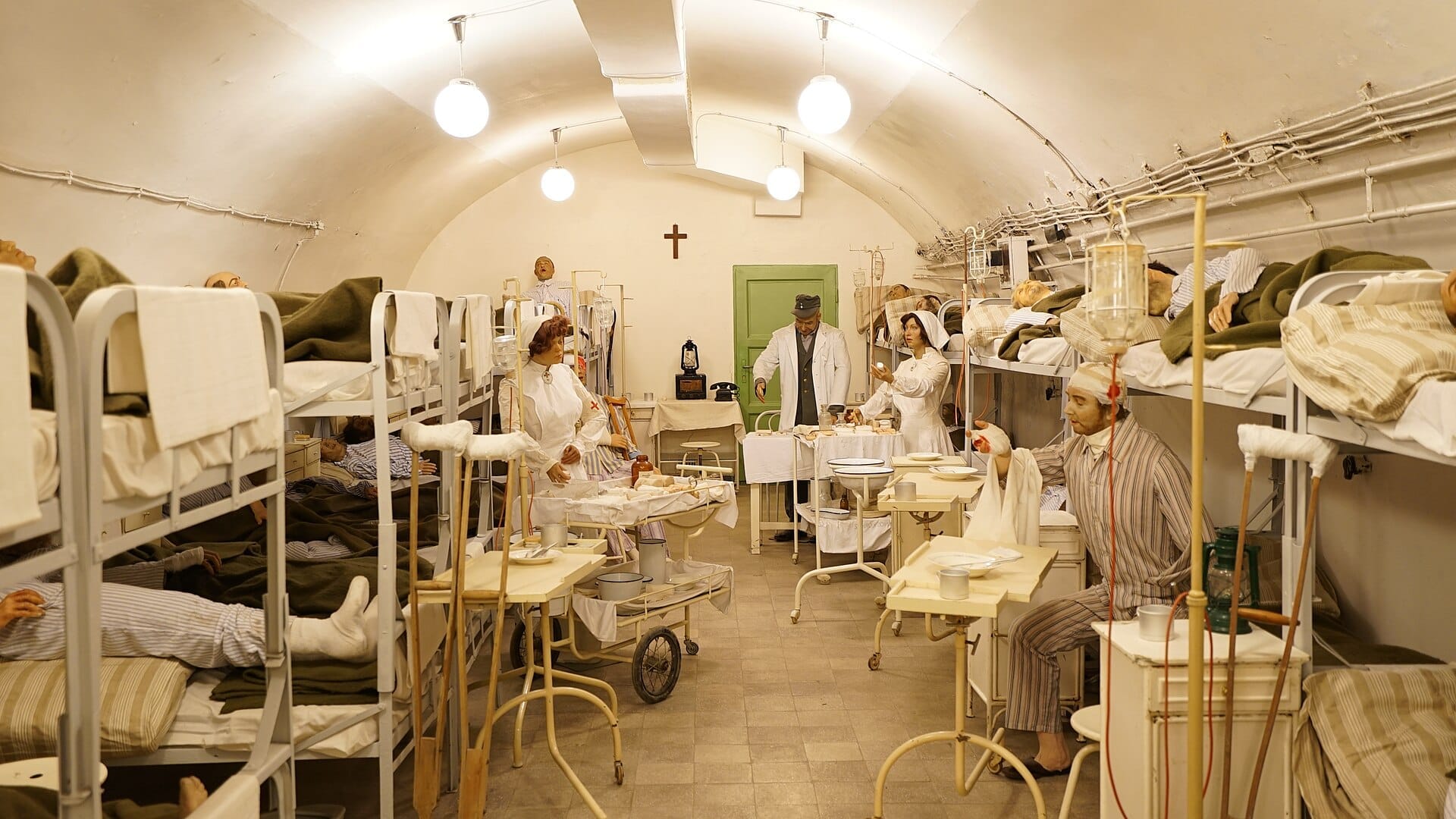 Nachgebaute Krankenhausstation aus dem Zweiten Weltkrieg im Hospital in the Rock, Budapest, mit Etagenbetten, Wachsfiguren des medizinischen Personals und Patienten unter Bogenlampen.