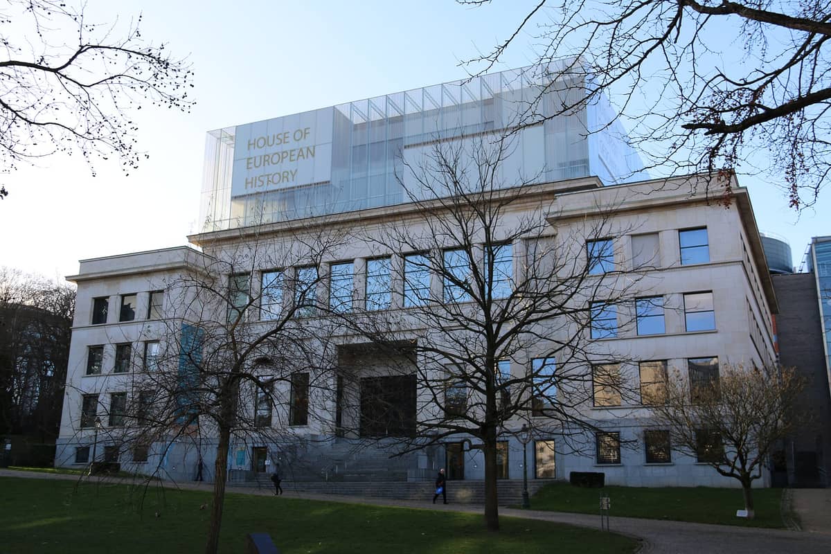 Vista externa do edifício da Casa da História Europeia no Parque Leopold, em Bruxelas, com a sinalização moderna do museu visível na fachada superior.