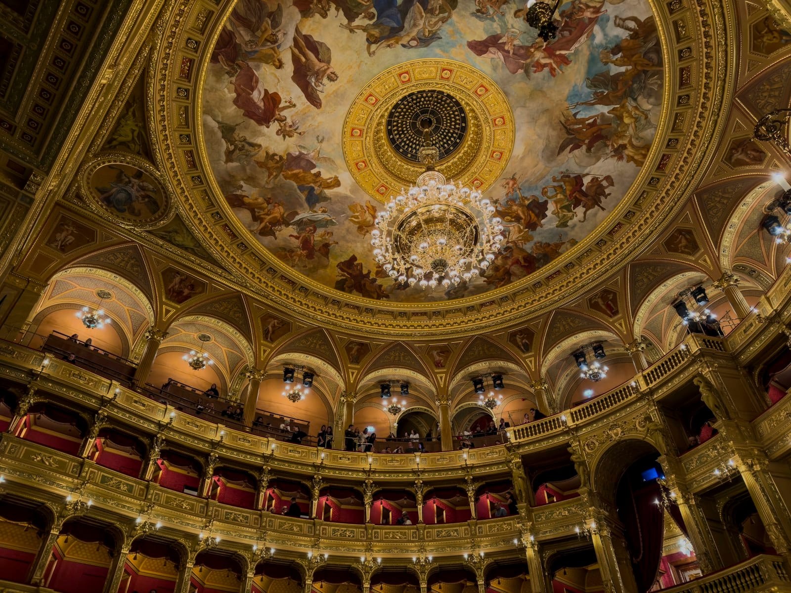 Auditorium berhias emas dan langit-langit lukis dengan lampu gantung di dalam Hungarian State Opera House Budapest.