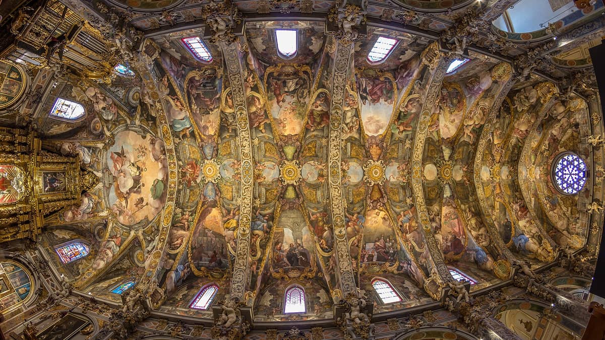 Vista panoramica delle volte riccamente decorate con affreschi della Iglesia de San Nicolás di Valencia, con vivaci pitture rinascimentali e intricati dettagli architettonici.