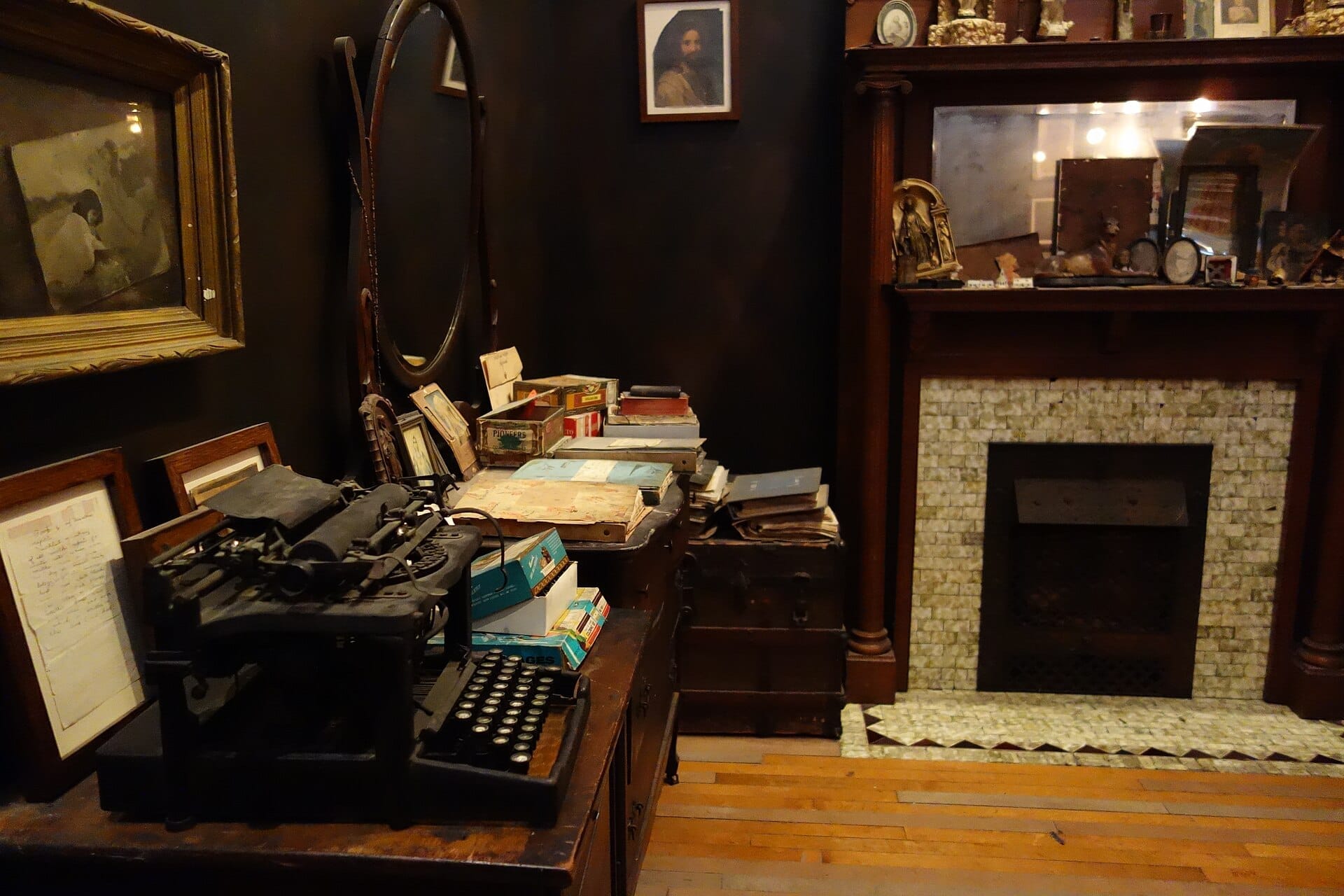 Una macchina da scrivere antica, libri vintage impilati e foto incorniciate riempiono una stanza fiocamente illuminata all'interno dell'Intuit Art Museum di Chicago.