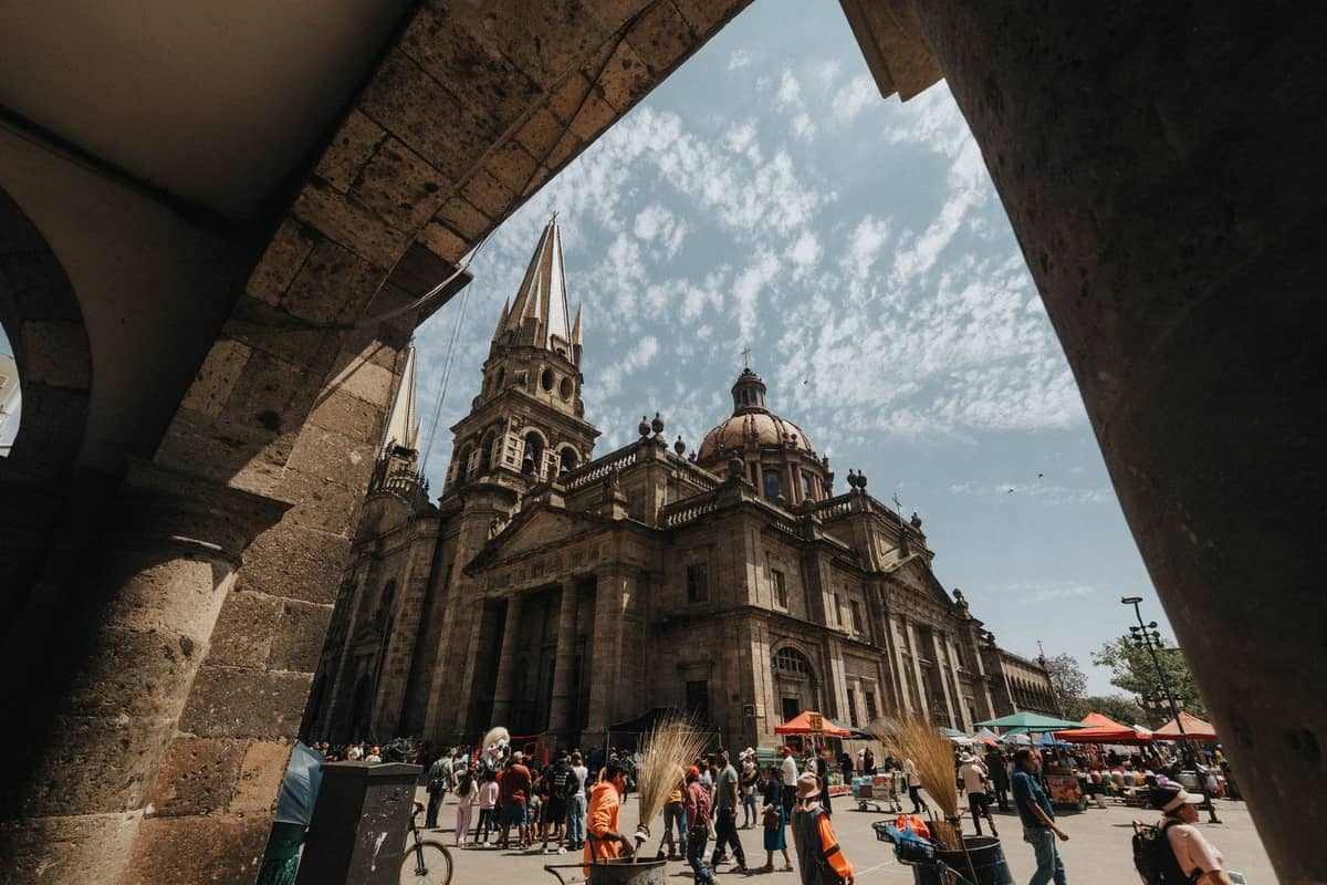 Menschenmenge bei Tageslicht vor der Kathedrale von Guadalajara mit lebhaften Straßenhändlern und sichtbaren Familien